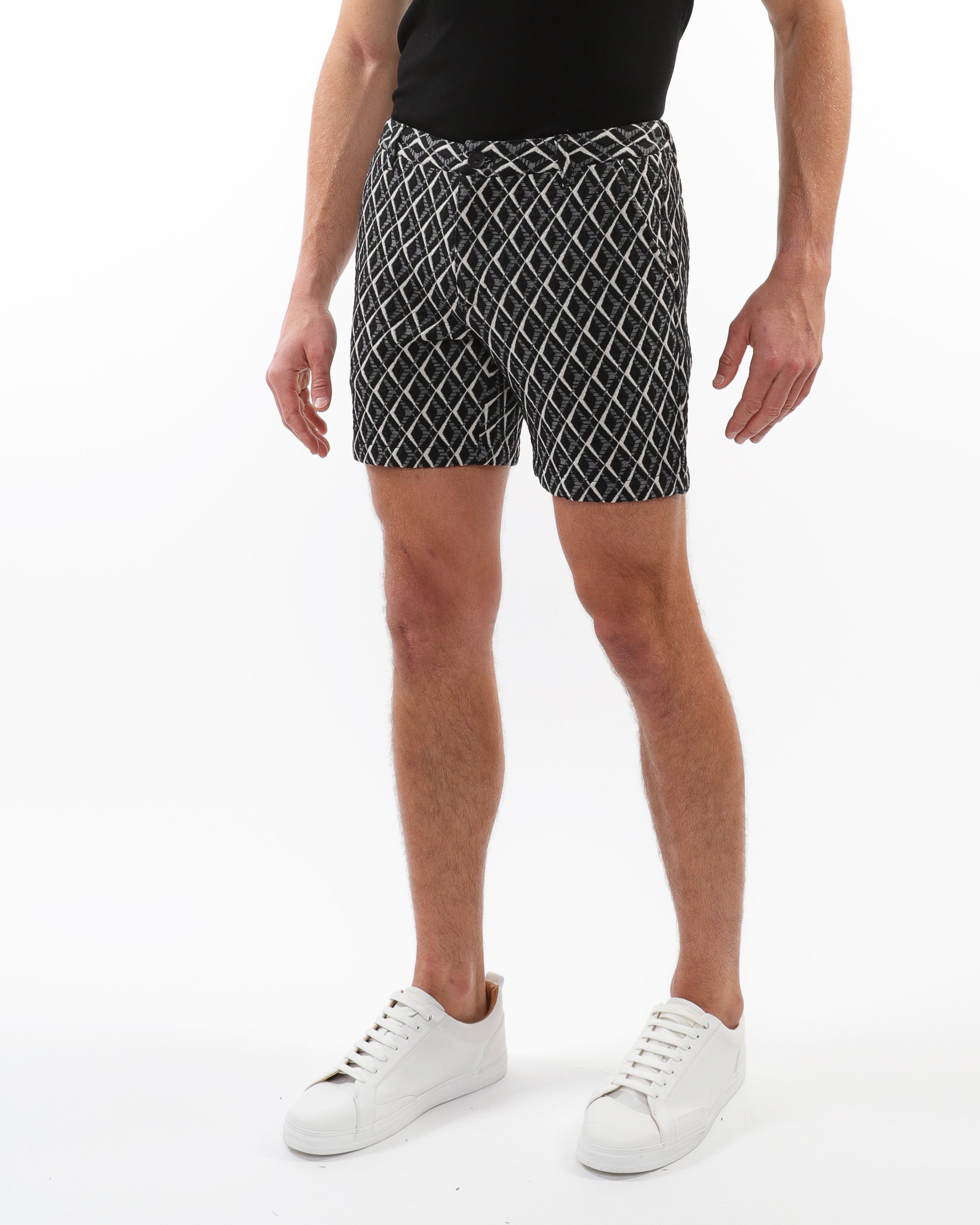 Person wearing black and white patterned shorts on a white background