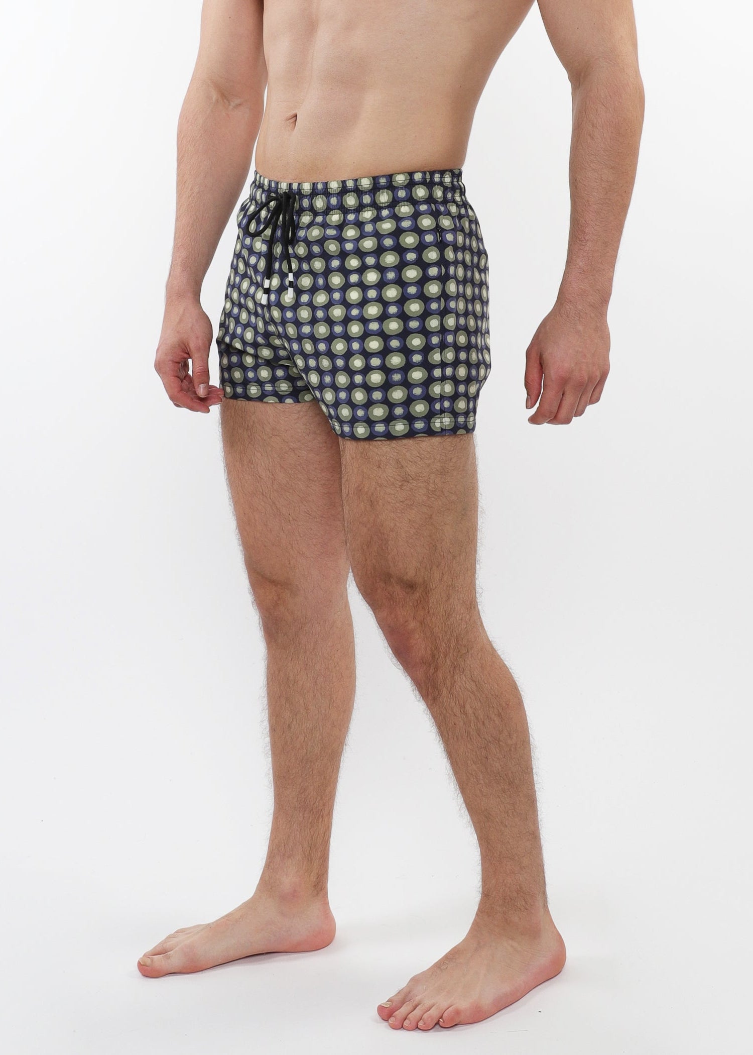 Man wearing patterned swim shorts on a white background