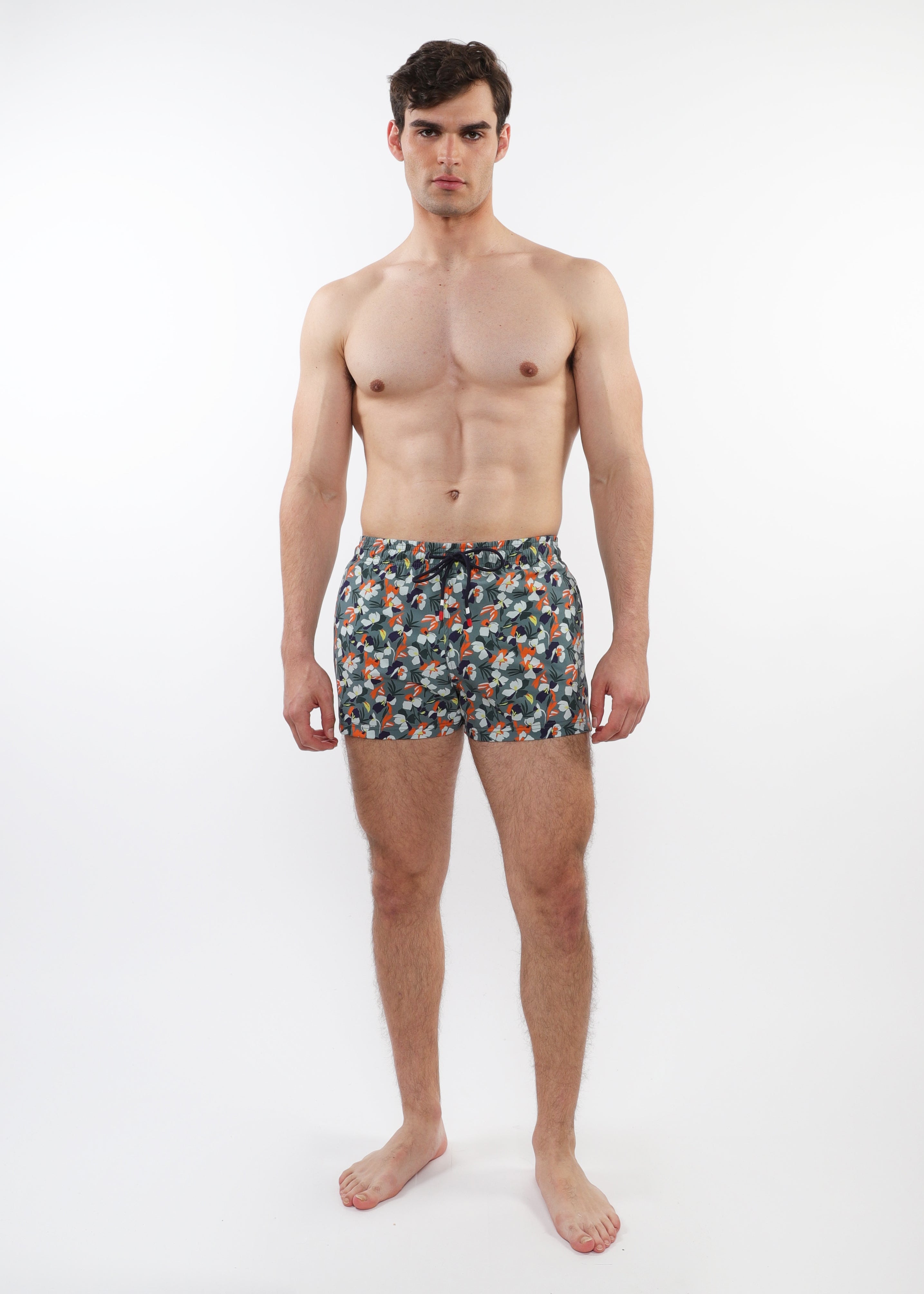 Man wearing patterned swim shorts on a white background