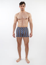 Man wearing patterned swim shorts on a white background