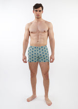 Man wearing patterned swim shorts on a white background