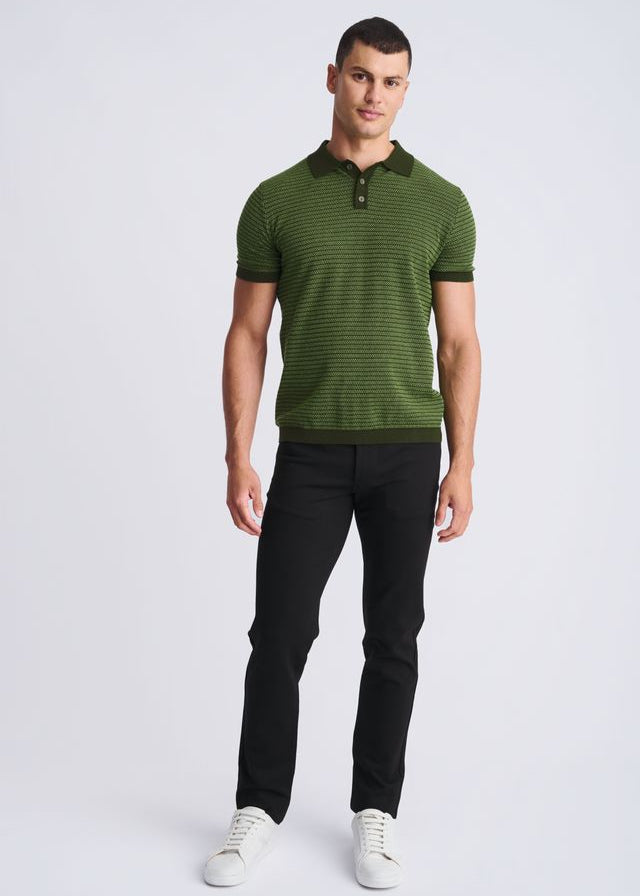 Man wearing a green striped polo shirt and black pants on a white background