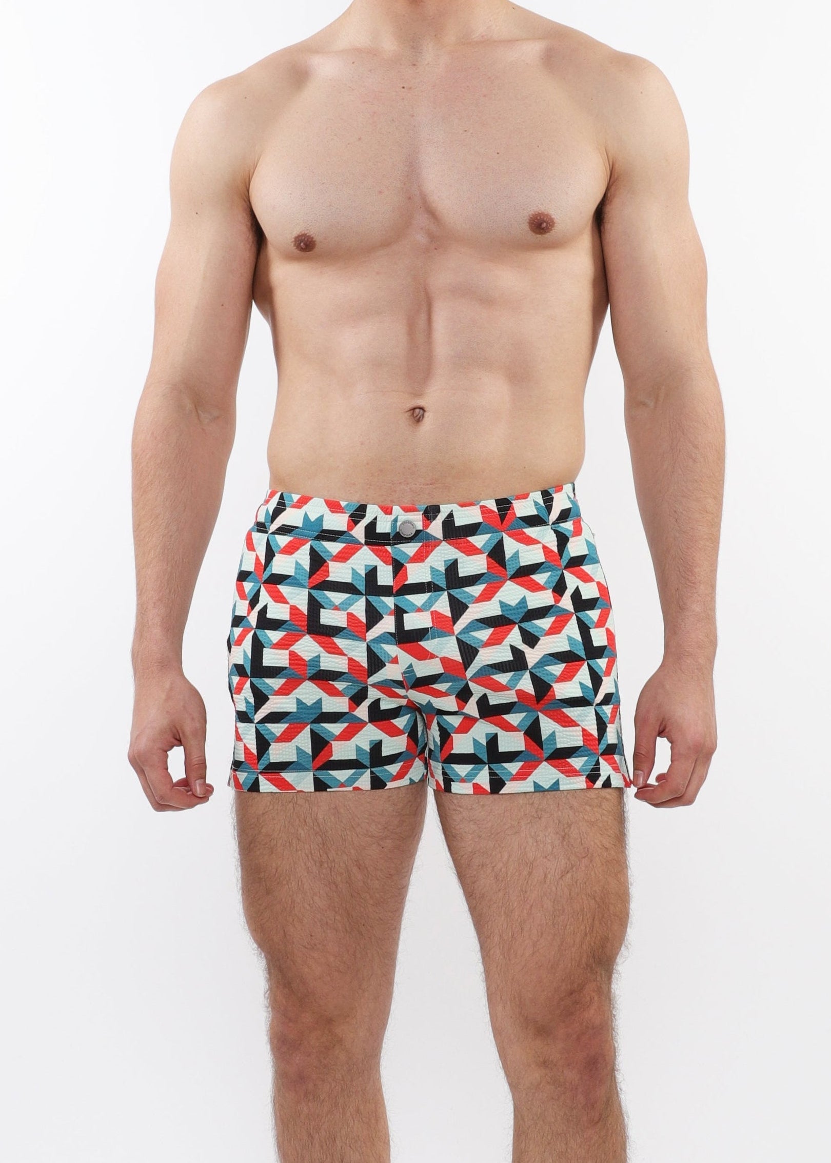 Man wearing colorful geometric patterned swim shorts on a white background